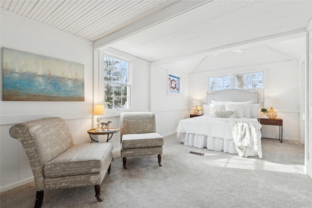 carpeted bedroom with vaulted ceiling with beams