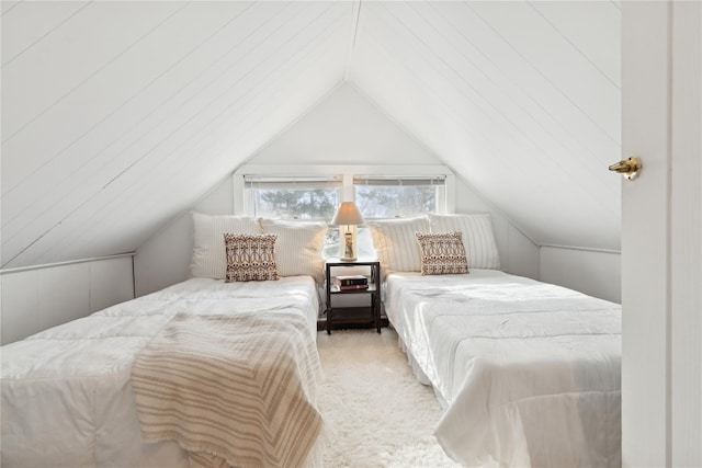 carpeted bedroom with lofted ceiling