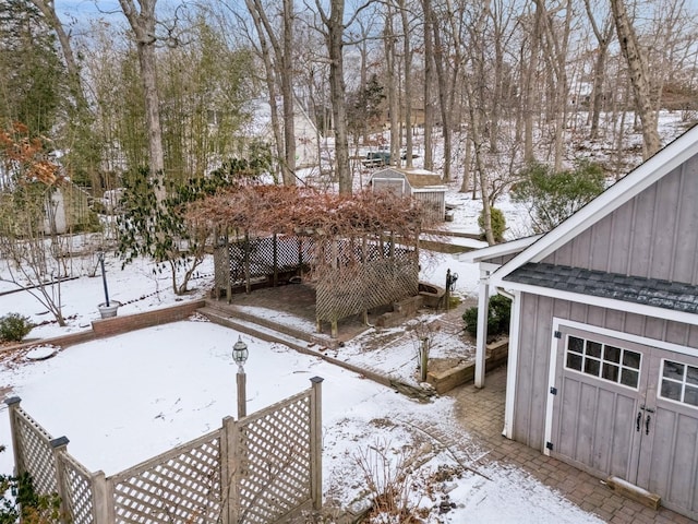 snowy yard featuring a shed