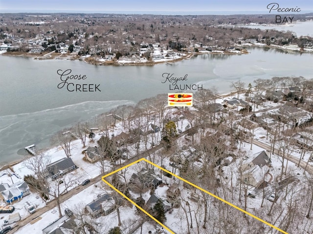 snowy aerial view with a water view