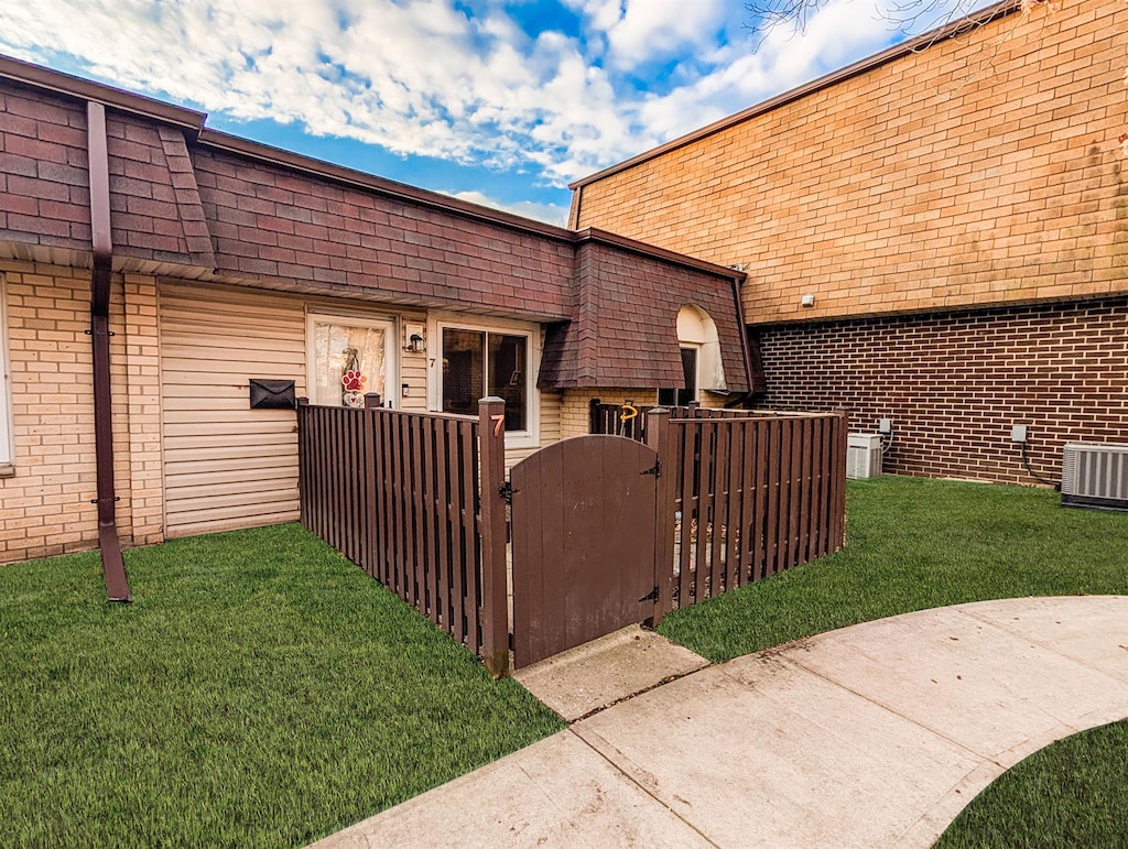 view of side of home with cooling unit and a yard