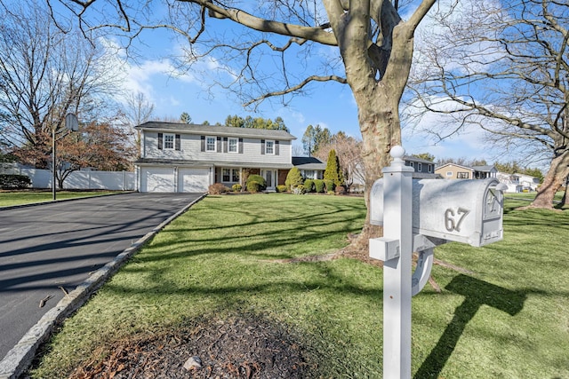 view of front of home with a front lawn and a garage