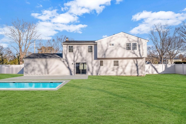 rear view of house featuring a yard and a fenced in pool