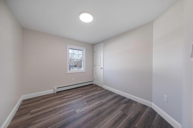 spare room featuring dark hardwood / wood-style flooring and a baseboard radiator