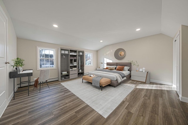 bedroom featuring a baseboard heating unit, dark wood-type flooring, and lofted ceiling