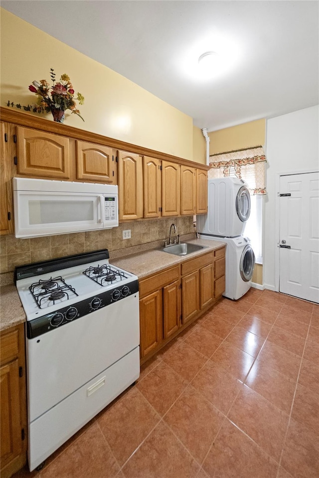 kitchen with sink, stacked washer / dryer, white appliances, light tile patterned floors, and decorative backsplash