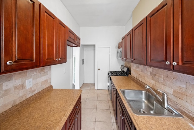 kitchen with stainless steel appliances, light tile patterned floors, sink, and backsplash