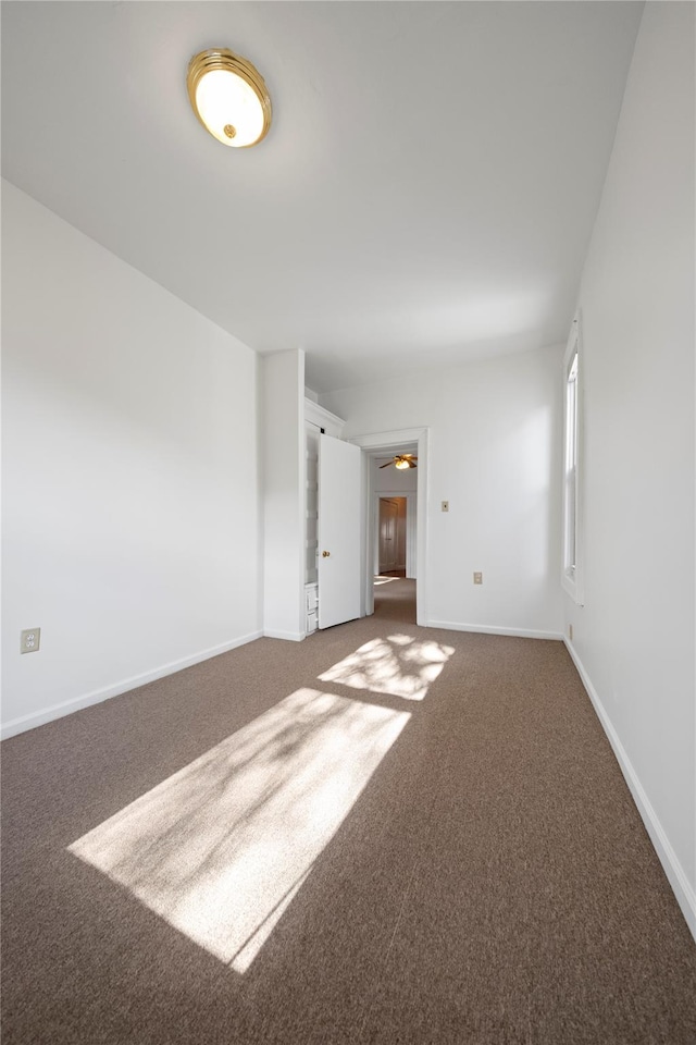 carpeted spare room featuring ceiling fan