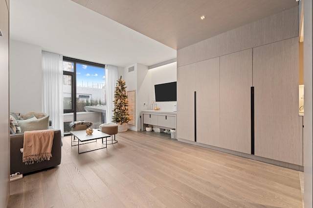 living room featuring floor to ceiling windows and light wood-type flooring