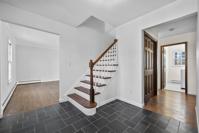 staircase with hardwood / wood-style floors and a baseboard heating unit