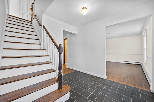 stairs with baseboard heating and hardwood / wood-style floors