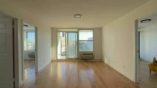 spare room featuring cooling unit and light hardwood / wood-style floors