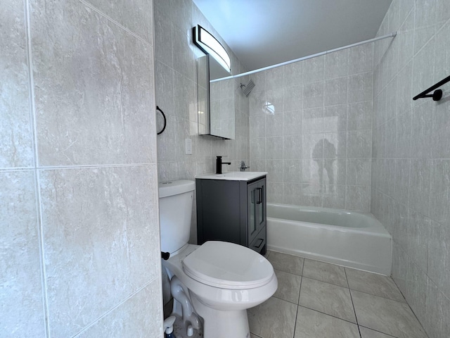 full bathroom with toilet, tiled shower / bath, tile walls, vanity, and tile patterned flooring