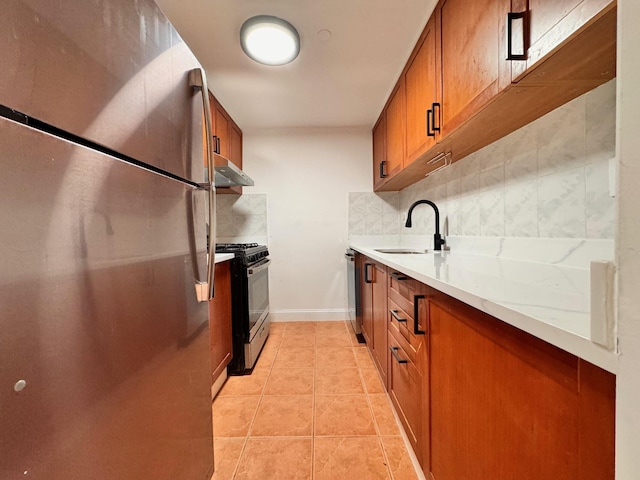 kitchen featuring sink, decorative backsplash, light tile patterned floors, light stone counters, and stainless steel appliances