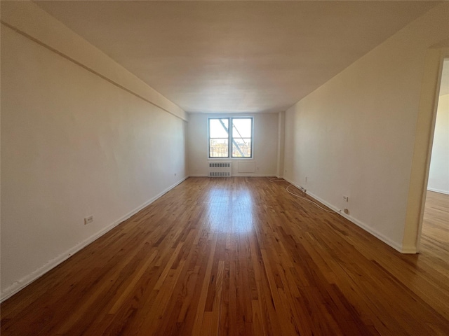 unfurnished room with wood-type flooring and radiator