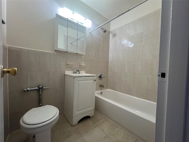 full bathroom with toilet, vanity, tile walls, tiled shower / bath, and tile patterned floors