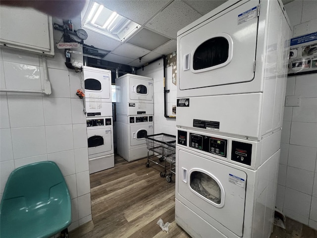 washroom featuring stacked washer / dryer and wood-type flooring