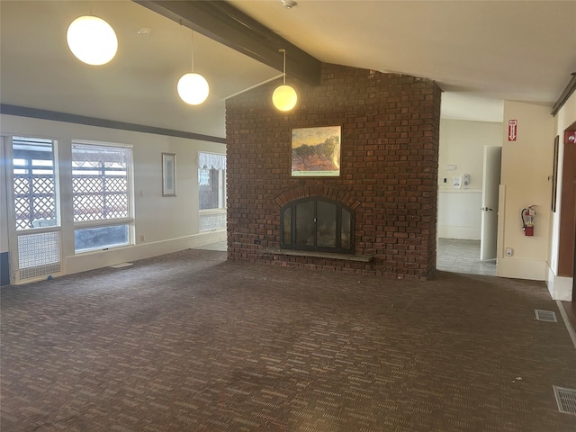 unfurnished living room featuring a brick fireplace, dark carpet, and vaulted ceiling with beams