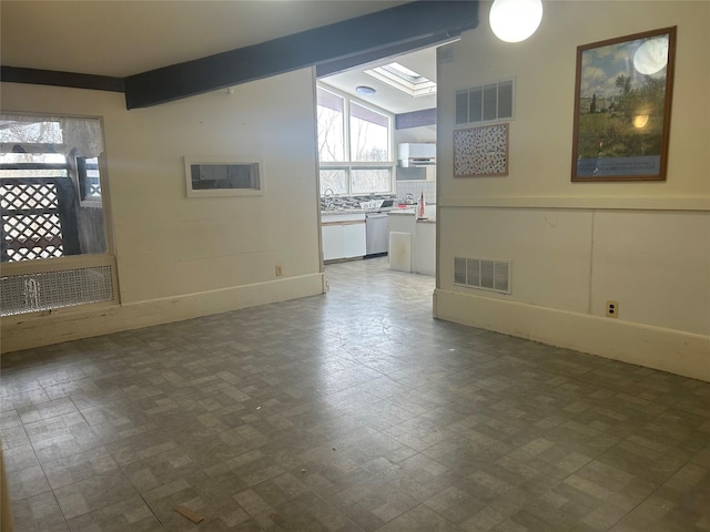 unfurnished room featuring beamed ceiling