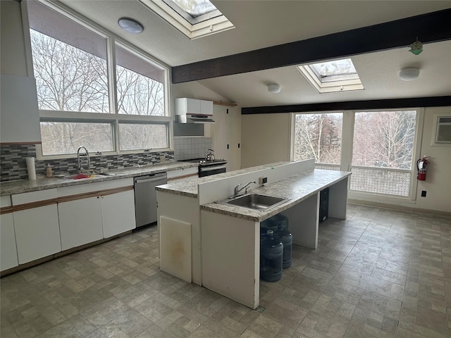 kitchen featuring white cabinets, sink, a kitchen island with sink, stainless steel dishwasher, and lofted ceiling with skylight