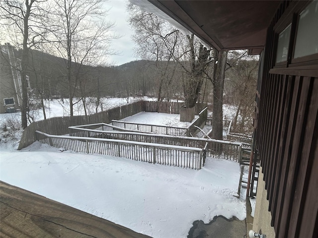 snow covered deck with a mountain view