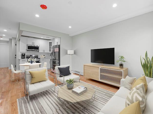 living room with light hardwood / wood-style flooring and a baseboard radiator