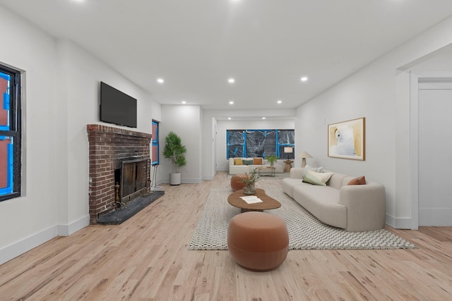 living room featuring light hardwood / wood-style floors and a brick fireplace