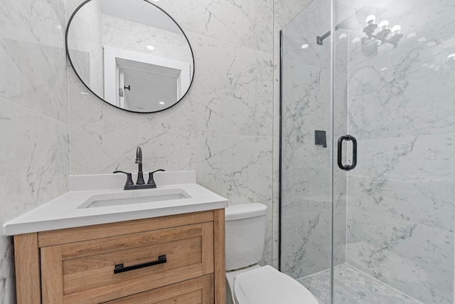 bathroom featuring a shower with door, vanity, and toilet