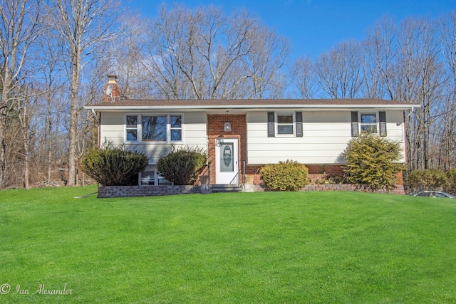 split foyer home with a chimney and a front yard