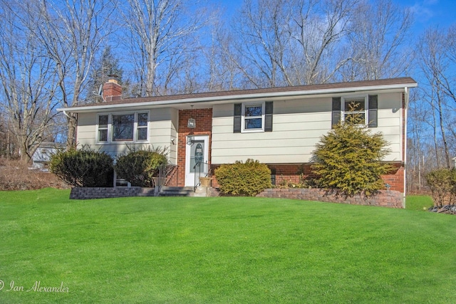 split foyer home with a chimney and a front yard