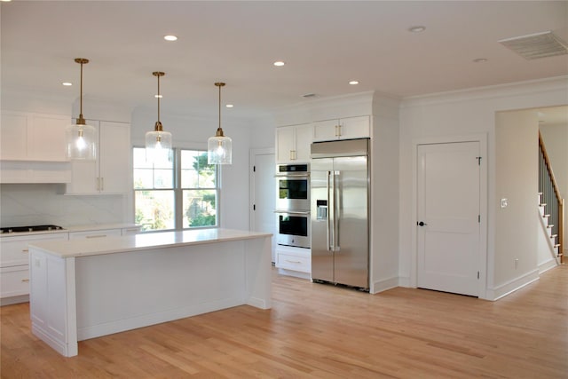 kitchen with white cabinets, appliances with stainless steel finishes, and a center island