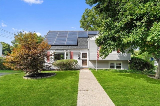 view of front facade featuring a front lawn and solar panels