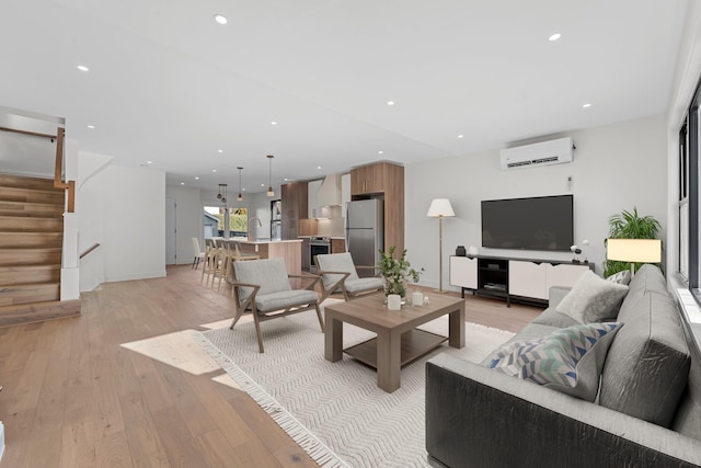 living room featuring a wall mounted AC and light wood-type flooring