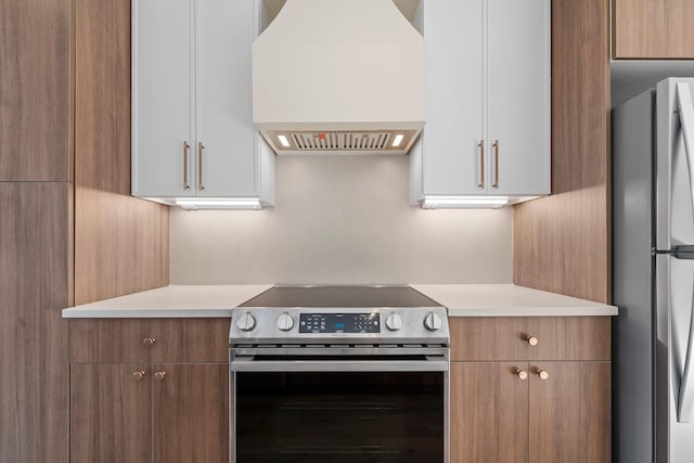 kitchen featuring appliances with stainless steel finishes, white cabinetry, and custom exhaust hood