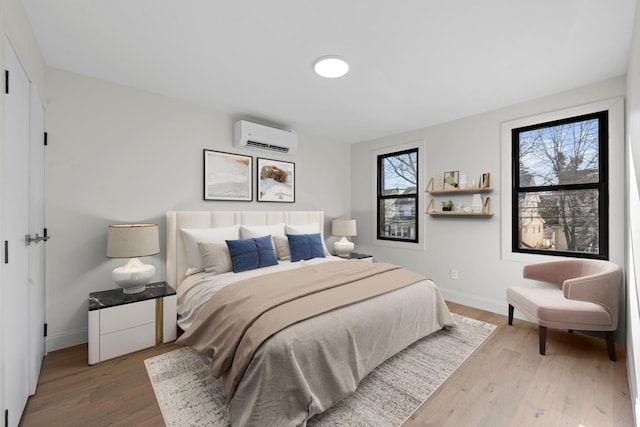 bedroom with wood-type flooring and an AC wall unit