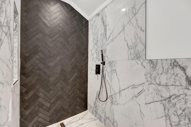 bathroom featuring a tile shower and crown molding