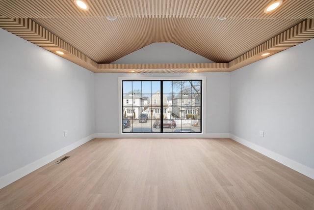 empty room featuring lofted ceiling and light wood-type flooring