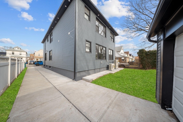 view of home's exterior with a yard, central air condition unit, and a patio area