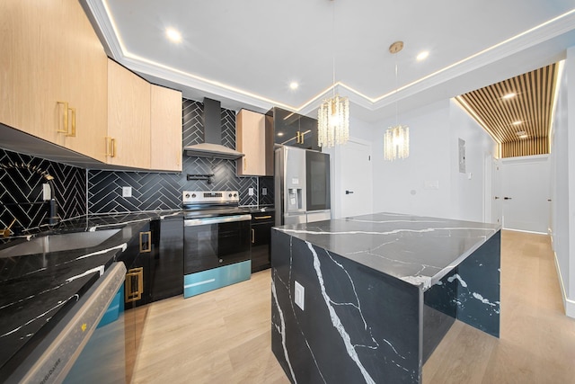 kitchen with pendant lighting, dark stone countertops, a center island, stainless steel appliances, and wall chimney exhaust hood