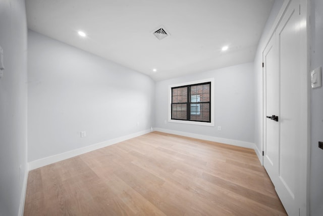 unfurnished room with light hardwood / wood-style flooring and vaulted ceiling