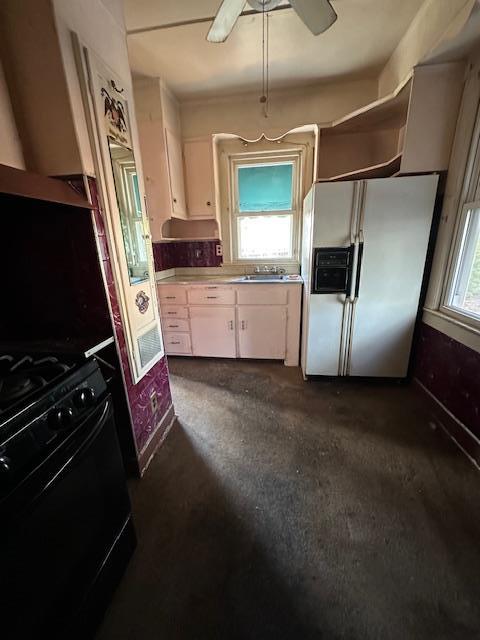 kitchen featuring ceiling fan, stainless steel fridge, and black range with gas cooktop