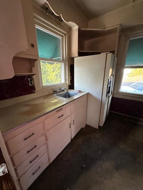 kitchen featuring white cabinets, a healthy amount of sunlight, sink, and white refrigerator with ice dispenser