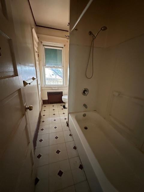 bathroom featuring tile patterned floors, toilet, and shower / washtub combination