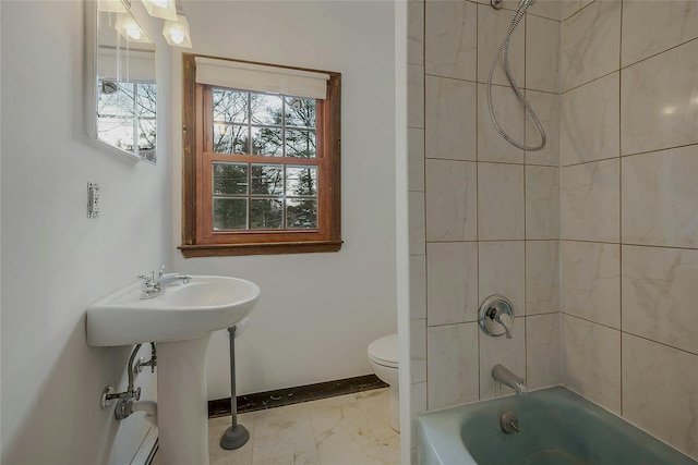 bathroom with tiled shower / bath combo and toilet