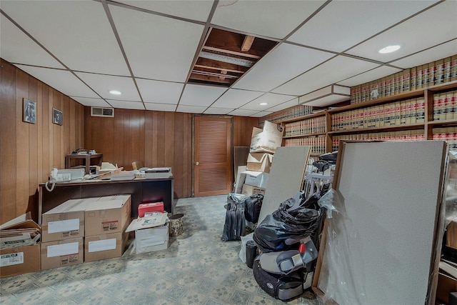 interior space with wooden walls and a paneled ceiling