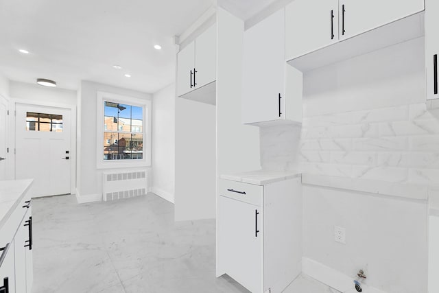 kitchen with white cabinets and radiator heating unit