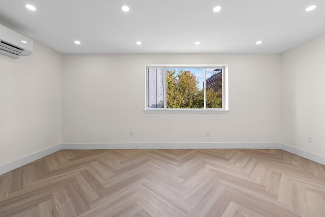 unfurnished room featuring an AC wall unit and light parquet floors