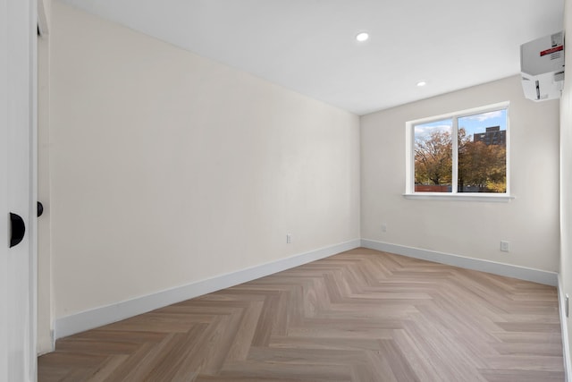 empty room with light parquet flooring and a wall mounted AC