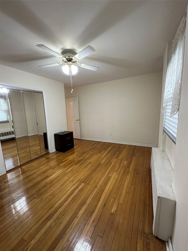 unfurnished bedroom with ceiling fan and hardwood / wood-style floors