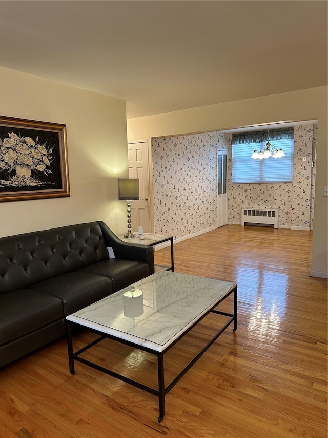 living room featuring an inviting chandelier, light hardwood / wood-style flooring, and radiator heating unit